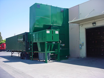 Enclosed extended height bin
dumper, with elevated hopper
and compactor for trailer transport